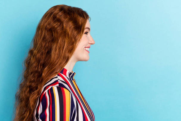 Profile photo of optimistic orange hairdo millennial lady look empty space wear colorful shirt isolated on blue color background - Foto, imagen
