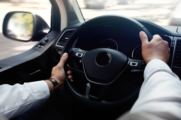 Man driving his car, closeup view of hands on steering wheel - Foto, Bild