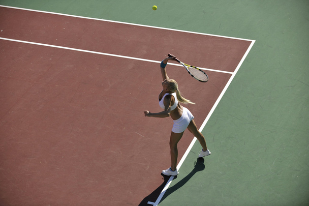 Young woman play tennis outdoor - 写真・画像