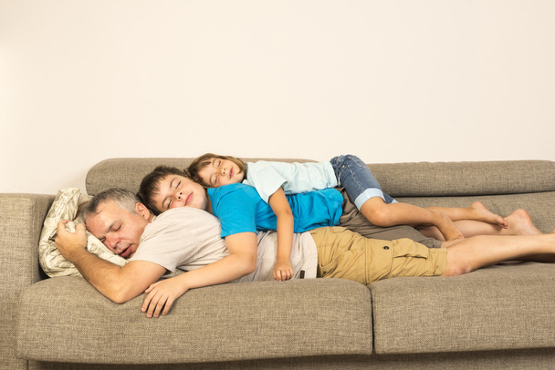 Padre e hijos durmiendo en el sofá
 - Foto, Imagen
