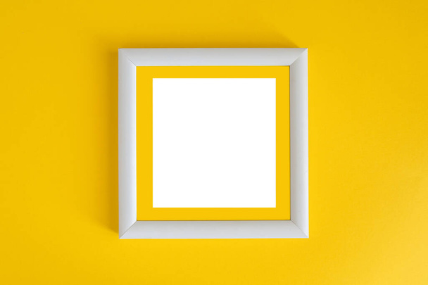White wooden photo frame on a yellow background. Minimalism. - Photo, Image