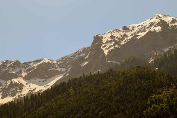 A scenic view of a snow-capped mountain under a clear sky - Photo, image