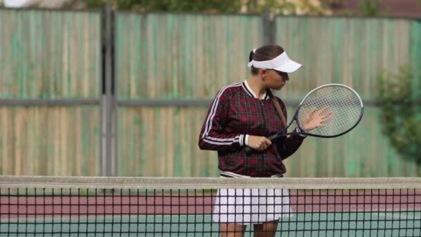 Svůdná sebevědomá žena hrající tenis na hřišti - Záběry, video