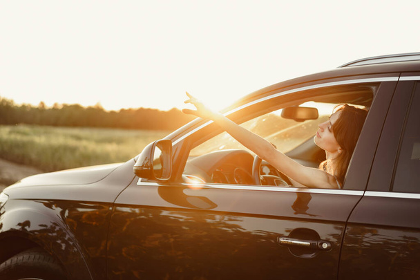 Beautiful smiling woman driving her car in the morning - Foto, imagen