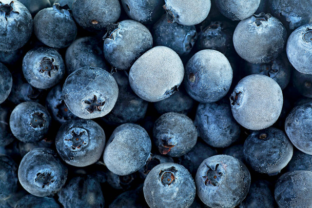 Closeup of frozen blueberries covered by frost, top view. Healthy breakfast. - Фото, изображение