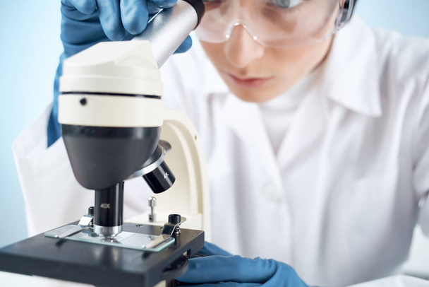 female laboratory assistant in medical gloves microscope biotechnology medicine - 写真・画像