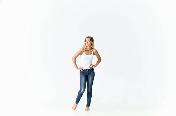 красивая блондинка в джинсах босиком позируя моды изолированный фон - Фото, изображение