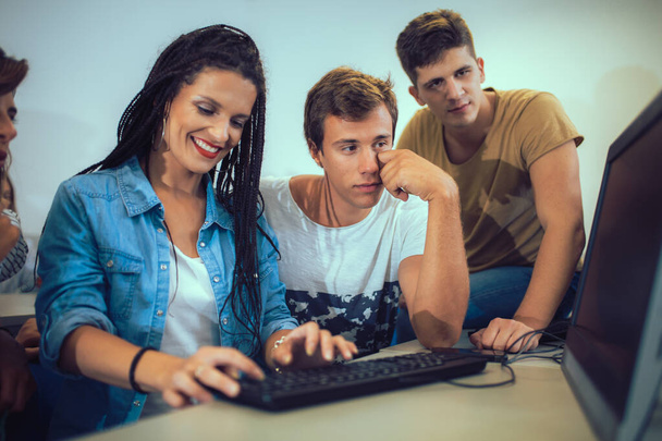 College-Studenten sitzen in einem Klassenzimmer und benutzen Computer während des Unterrichts. - Foto, Bild