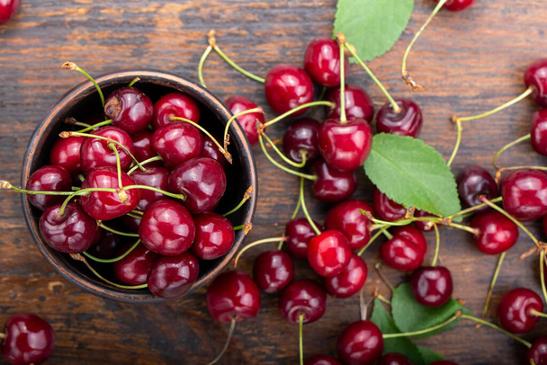Freshly harvested cherries in a clay bowl from your home garden. Healthy food concept - Foto, Bild
