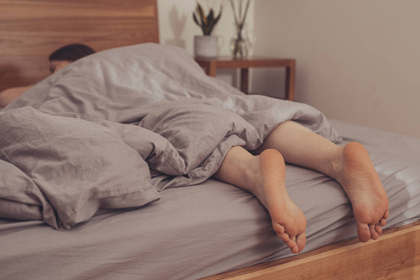 Feet of woman sleeping in bed at home - Valokuva, kuva