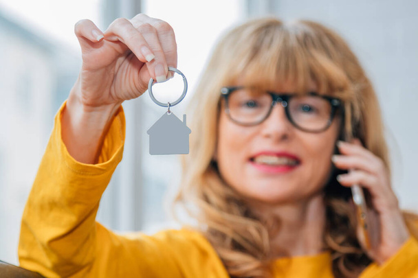 woman with house keys talking on mobile phone - Photo, Image