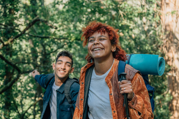 молода багатоетнічна пара з рюкзаками пішохідний або пішохідний туризм
 - Фото, зображення