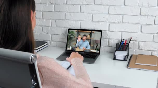 Женщина на домашнем обучении онлайн видео вызова ноутбука слушать учителя, пишет в ноутбуке - Кадры, видео