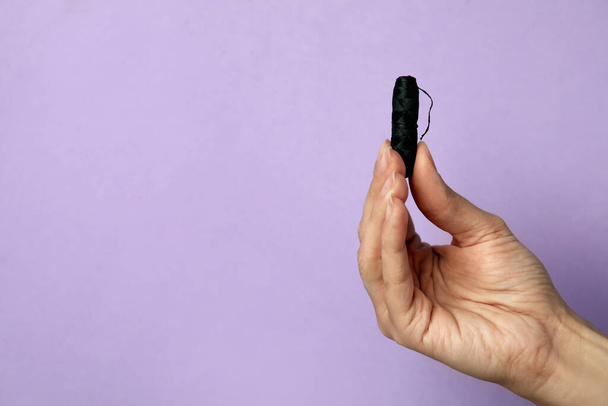 Woman holding biodegradable dental floss against lilac background, closeup. Space for text - Φωτογραφία, εικόνα