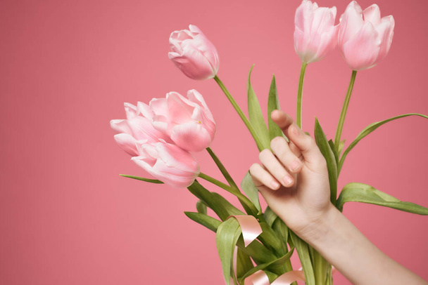 bouquet of flowers in hand on pink background. High quality photo - Zdjęcie, obraz