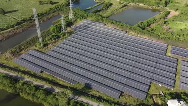 4K en Solar Farm de vista de ojos de pájaro. Estación de células solares en antena con naturaleza verde alrededor del área. - Imágenes, Vídeo