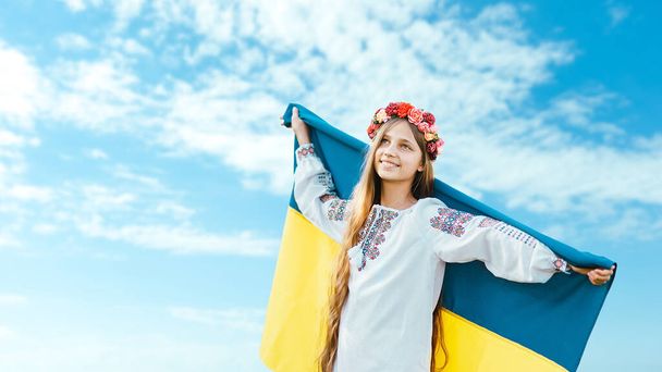 Ukraines Independence Flag Day. Constitution day. Ukrainian child girl in embroidered shirt vyshyvanka with yellow and blue flag of Ukraine in field. flag symbols of Ukraine. Kyiv, Kiev day - Foto, afbeelding