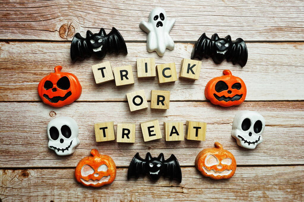 Halloween concept flat lay Trick or Treat alphabet letters on wooden background - Фото, изображение