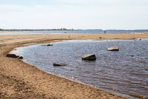 Un hombre solitario está caminando en la orilla de la arena en Kalajoki, Finlandia. Por lo general, estos bancos están llenos de gente en los días de verano. - Foto, Imagen