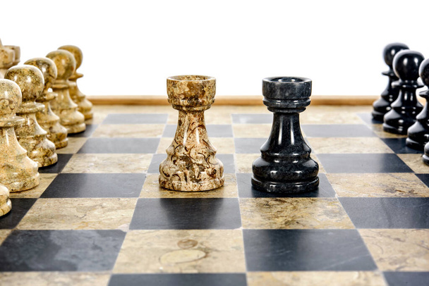 dos piezas de ajedrez de torre como rivales, en el centro en el tablero de ajedrez de mármol de coral beige y negro. Primer juego concepto de competencia, Torneo Clásico. - Foto, imagen
