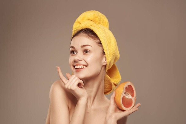 женщина с полотенцем на голове чистая кожа грейпфрута в руке обрезанный вид - Фото, изображение
