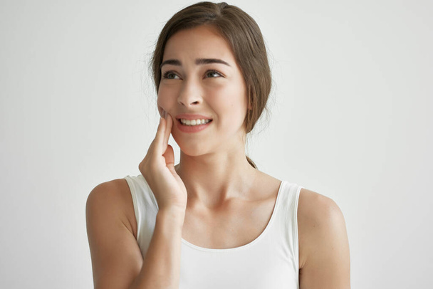 woman in white t-shirt teeth pain dentistry discomfort - 写真・画像