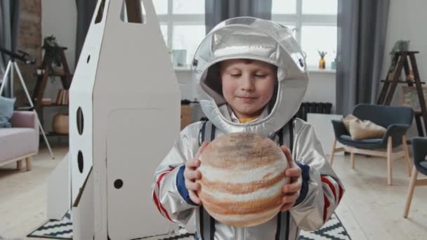 Retrato de mão tiro de menino adorável de 6 anos em modelo de exploração espacial do planeta e sorrindo para a câmera - Filmagem, Vídeo