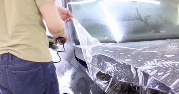 Dekking auto met beschermende folie om het te beschermen tegen krassen en scuffs 4k film - Video