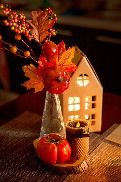 Украшение кухни на Хэллоуин и осень - светящийся картонный домик, свеча, букет с осенними листьями, хурма - Фото, изображение