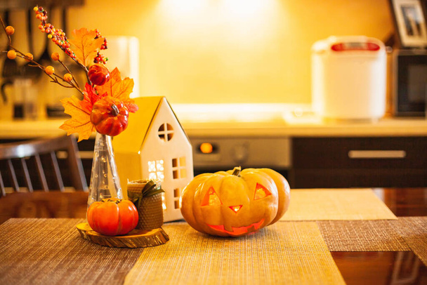 Cadılar Bayramı ve Sonbahar için mutfak dekorasyonu - parlak karton ev, mum, sonbahar yapraklı buket, hurma, balkabağı-fener. - Fotoğraf, Görsel