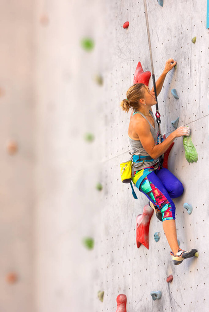 rock climber climbs the route. climbing wall in the city for extreme sports. - Photo, Image