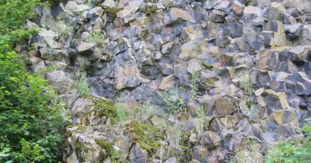 Pendiente de montaña hecha de roca de basalto en el lago - Imágenes, Vídeo