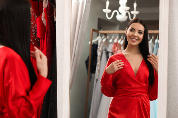 Woman trying on dress in clothing rental salon - Photo, Image
