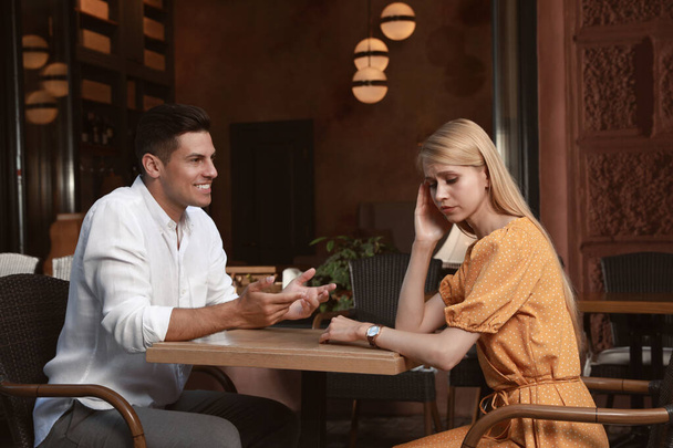 Young woman having boring date with talkative man in outdoor cafe - Foto, afbeelding