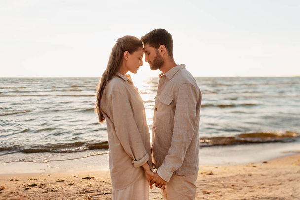 happy couple holding hands on summer beach - 写真・画像