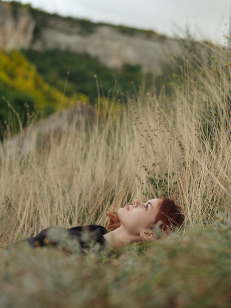 Žena v černých šatech leží na trávě, příroda odpočívá - Fotografie, Obrázek