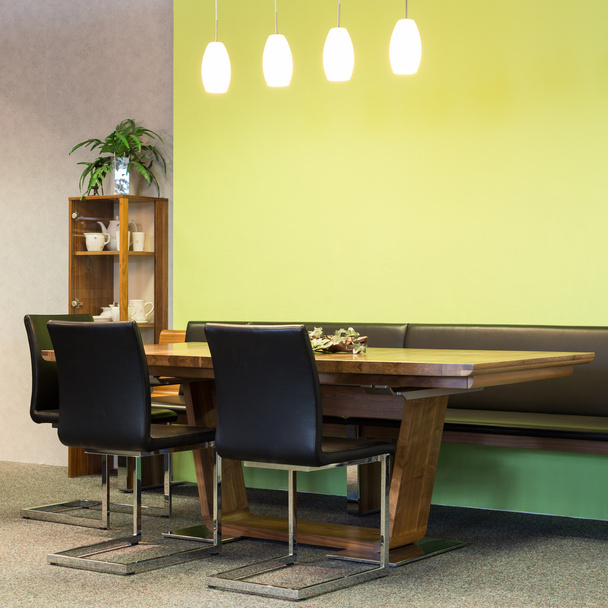 Vista su tavolo in legno con sedie in pelle in sala da pranzo con illuminazione
 - Foto, immagini