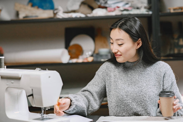 Professional young female tailor working in workshop - 写真・画像