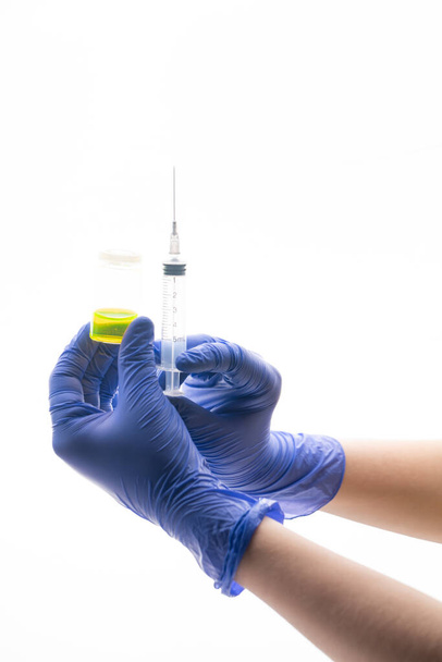Doctor's or nurse hands in medical gloves holding syringe and bottle of with an injection solution liquid. Injection vaccine, medicine flu, influenza concept. Vaccination. Medication or drug. Selective focus. Copy space - Φωτογραφία, εικόνα