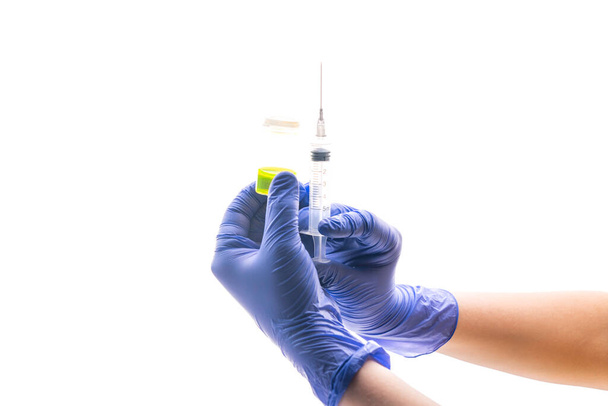 Doctor's or nurse hands in medical gloves holding syringe and bottle of with an injection solution liquid. Injection vaccine, medicine flu, influenza concept. Vaccination. Medication or drug. Selective focus. Copy space - Photo, Image