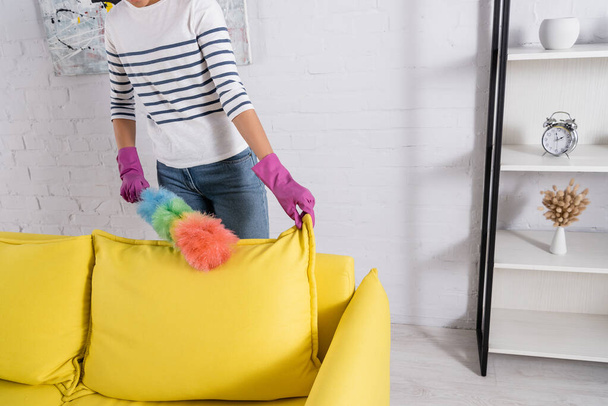 Vista recortada del sofá de limpieza de la mujer durante las tareas domésticas  - Foto, Imagen
