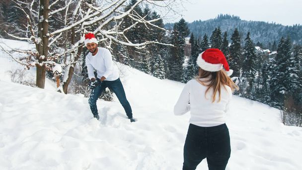 una giovane coppia innamorata di giocare in vena sulla neve vicino a un albero - Foto, immagini