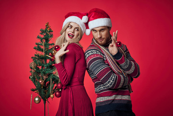 homem e mulher ano novo árvore decoração feriado fundo vermelho - Foto, Imagem