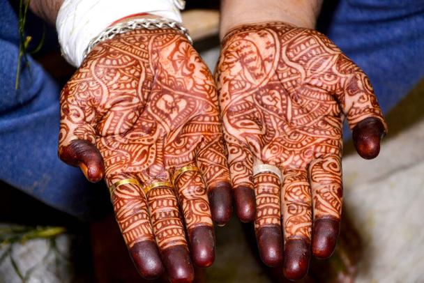 Schönes Kunstwerk von Henna Mehndi auf den Händen eines indischen Bräutigams, Henna-Farbstoff wird während des indischen Hochzeitsfestes auf die Hand eines Mannes aufgetragen - Foto, Bild