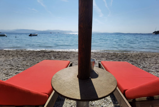 corflu o kerkyra y sombrillas en ipsos playa con palmeras vacaciones de verano resort en greee - Foto, imagen