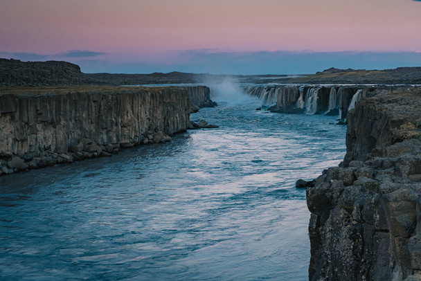 Beautiful Selfoss waterfall in the Dettiffos area, large amount of water falling down making a droplet curtain during summer sunset in rich colors. Nice evening next to a big waterfall. - Foto, Imagen