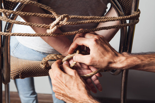 un homme libère une prisonnière d'une corde - Photo, image