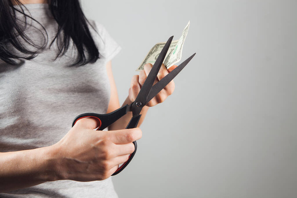 nő vágja a dollár számlát ollóval - Fotó, kép