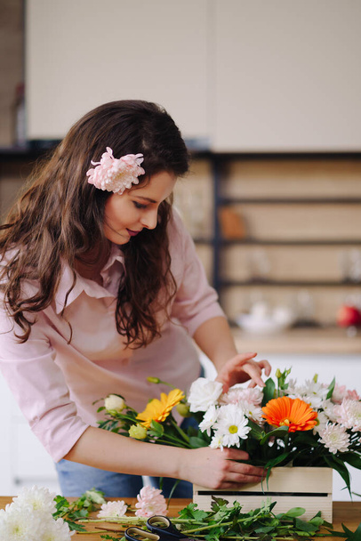 Красивый флорист организует цветочную композицию - Фото, изображение