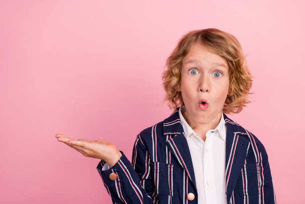 Photo of young school boy hold hand advert amazed shocked promo product offer isolated over pastel color background - 写真・画像